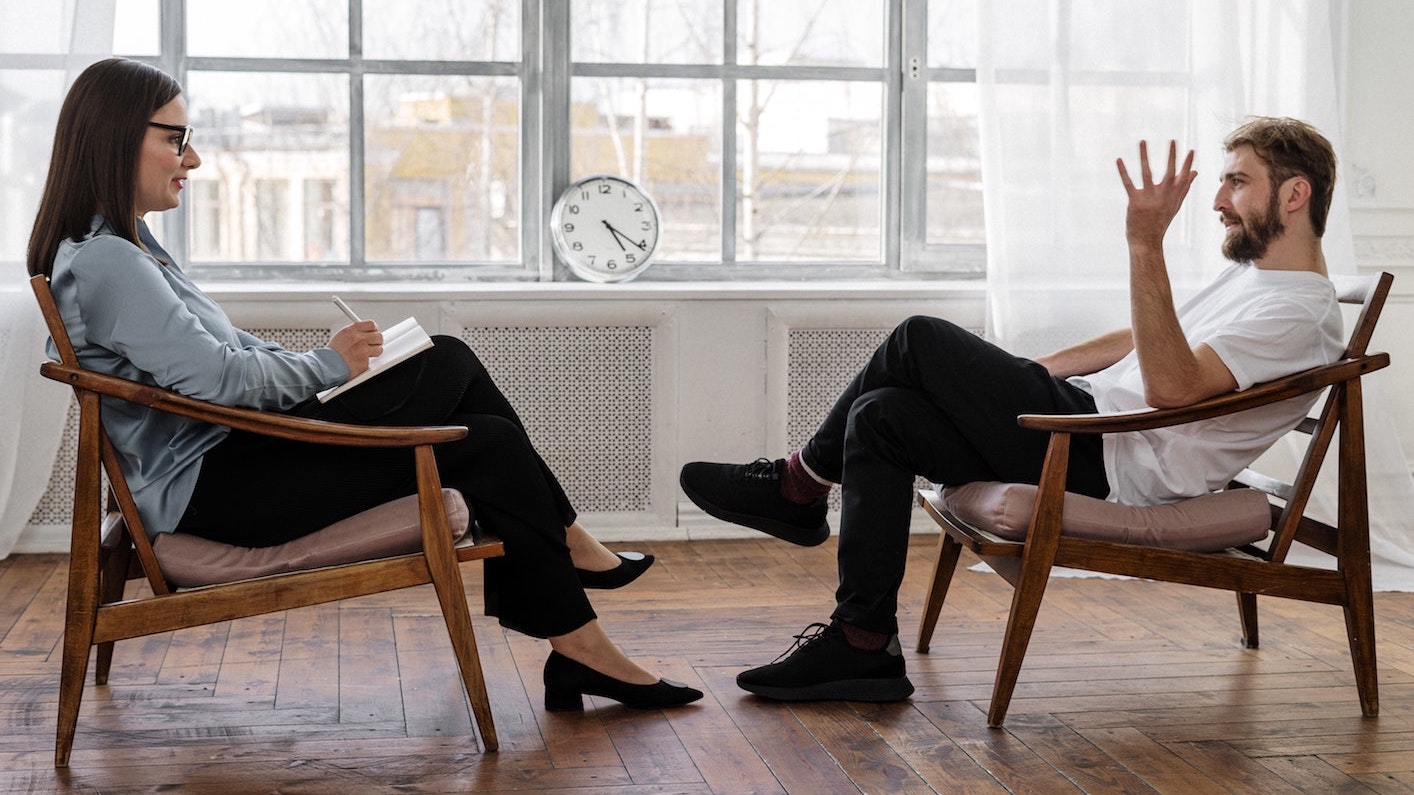 An image of two people sitting and talking